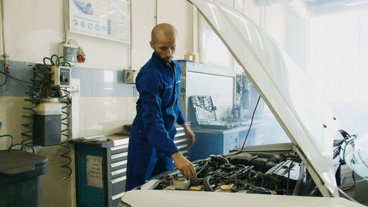 Technicien inspectant un véhicule lors d'une intervention