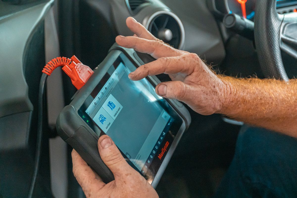 Technicien avec outil de diagnostic électronique