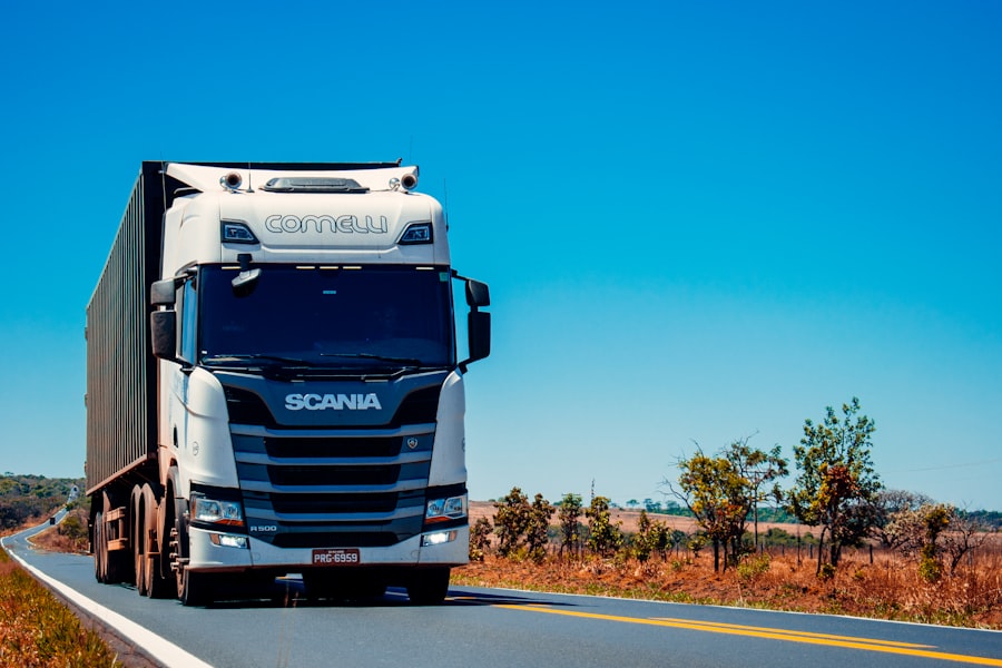 Camion plateau remorquant un véhicule sur autoroute